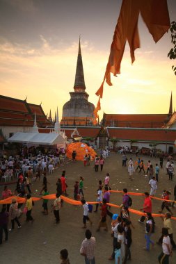 Nakhon Si Thammarat, Thailand - Feb 18 2011: Hae Pha Khuen That Festival (Festival fabric element) is celebrated at Phra Borom That Chedi (Pagoda). Buddhists bring cloth to wrap around the pagoda  clipart