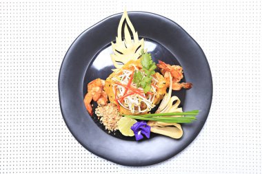 Karides Pad Thai, geleneksel Tayland yemeği. Kızarmış pirinç eriştesi, yukarıdan kırsal bir dokuda çekilmiş. 