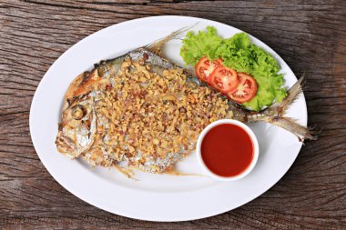 Deep-fried Diamond Trevally with Garlic, Diamond Trevally fried fish with Garlic. Food photography for use in menus 