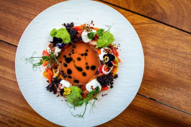 Görsel olarak göz kamaştırıcı ve gurme bir dizi canlı sebzenin merkezde büyüleyici turuncu renkli bir çorba ya da sosla tamamlanmış dairesel bir düzende bir araya geldiği yer..