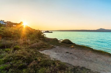 Gün batımında deniz kenarı sakinliği, kıyı gecesinin dingin sihrini özetliyor. Doğal hayatın güzelliği ile bir teselli ve bağlantı anı sunuyor.. 