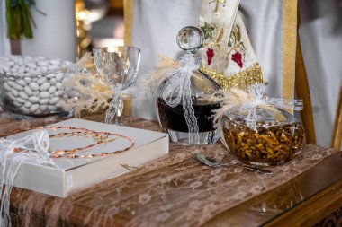 Bir kilisede düzenlenen Yunan düğün töreni: Stefana düğün tacı, kırmızı tatlı şarap sürahisi, sıradan fındıklı bal ve koufeta şekerli badem. Seçici odak