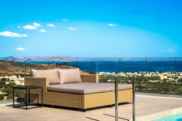 stock image Summertime Oasis: A luxurious double sun bed  with a panoramic view of the sea and surrounding landscape. This inviting scene captures the essence of summer, blending relaxation and sophistication.