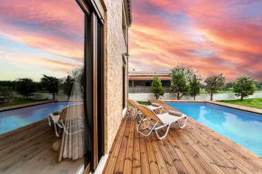 Tranquil Outdoor Retreat, Özel Havuz 'dan Sunbed' li Tahta Güverte. Kırsal kesimlerin cazibesini göstermek ya da lüks bir dokunuşla tatil ve eğlence kavramlarını teşvik etmek için idealdir..