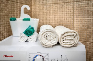 Irakleio, Girit, Yunanistan-20.03.24: Yıkama Makinesi Banyosu İçi Detayları Üzerine Yuvarlanmış Havlular. Modern tuvaletleri vurgulamak için mükemmel. Basit, zarif dekor detayı karmaşıklıkla ortamı yükseltir