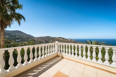 Şık balkonun resim gibi köşesinde zarif korkuluklar ve karmaşık tasarımlar var. Huzurlu dağların ve engin denizin çarpıcı bir görüntüsünü sunuyor. Lüks yaşamın özü, doğanın güzelliği.