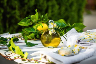 Yunan Ortodoks vaftizinin ayrıntıları. Süslü masaya yerleştirilmiş, vaftiz malzemeleri için hazırlanmış küçük bir şişe zeytinyağı. Dekorasyon, vaftiz töreninin ve Yunan Ortodoks ayinlerinin önemini vurguladı