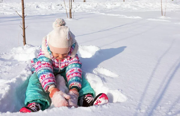 girl of 7-9 years old plays in the snow, a winter urban snow-covered landscape, a lot of snow, a child frolics on the street