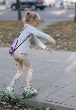 Küçük Avrupalı kız yaz tatilinde paten kaymayı öğrenip eğleniyor.