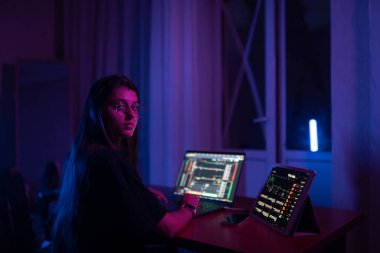 Attractive young woman working in home at night. Girl using laptop.