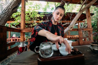Çay seremonisi. Kadın çay kasesine su döküyor. Yakın plan..