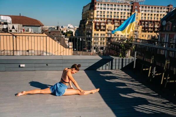 stock image Young woman practicing yoga on the roof