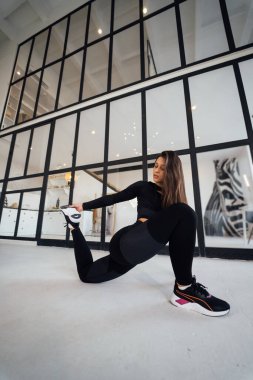 Side view of flexible girl exercising yoga pose indoors. Concept of yoga.