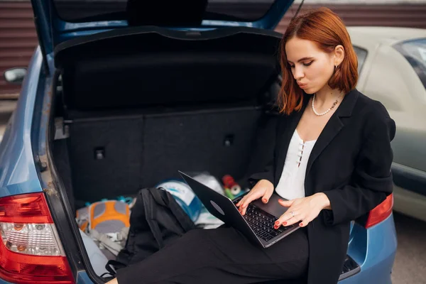 Çekici Genç Kadın Seyahat Ederken Arabanın Bagajında Otururken Dizüstü Bilgisayarda — Stok fotoğraf