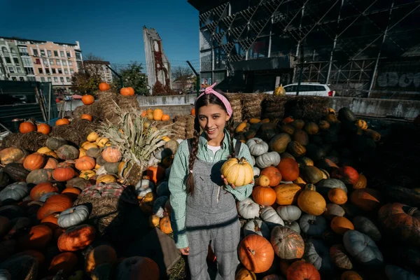 Młoda Sprzedawczyni Małą Dynią Pozuje Przed Kamerą Wśród Jesiennych Żniw — Zdjęcie stockowe
