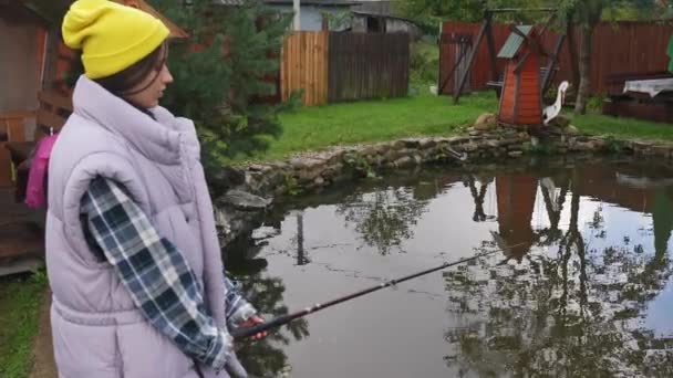 若い美しい女性は夏に小さな池で釣りをしています — ストック動画