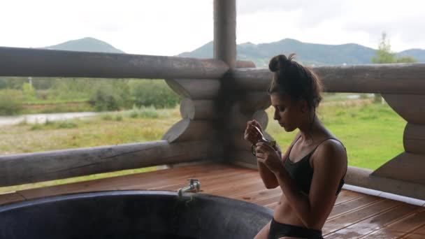 女性は露天風呂でリラックスし 山で温泉を楽しむ 山の中の夏休み — ストック動画