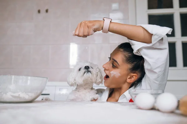 Fröhliche Junge Frau Spielt Mit Hund Während Sie Mehl Auf — Stockfoto