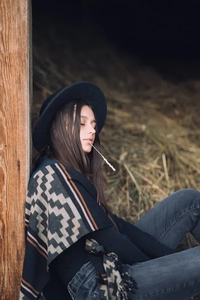 年轻的黑发女人坐在谷仓门口摆姿势 农村风格 — 图库照片
