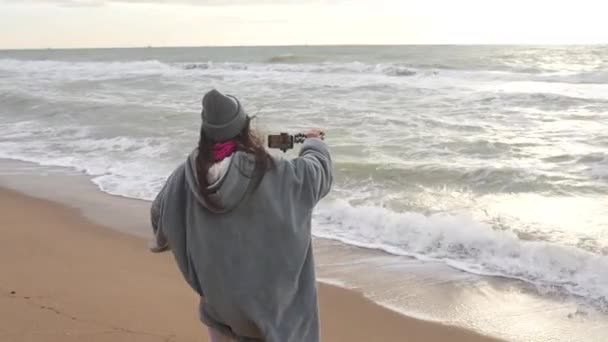 Μια Γυναίκα Κινηματογραφεί Φωτογραφίζει Τις Φουρτουνιασμένες Θάλασσες Από Την Παραλία — Αρχείο Βίντεο