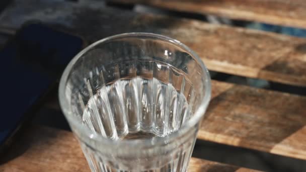 Ένα Ποτήρι Νερό Ένα Παγκάκι Στον Ήλιο — Αρχείο Βίντεο