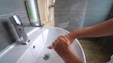 close up woman washing hands with soap and water, white foam, in the bathroom, under tap in the sink, personal hygiene and care, coronavirus prevention