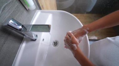 close up woman washing hands with soap and water, white foam, in the bathroom, under tap in the sink, personal hygiene and care, coronavirus prevention