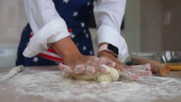 食事の終わりのための生地を作るプロセス エプロンの若い主婦が手で生地をこねる — ストック動画