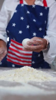 Kadın hamur yapmak için beyaz unun üzerinde yumurta kırıyor, yakından görmek için.