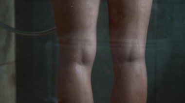 Duştan gelen su bacağına sıçrıyor..