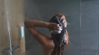 Duşta yıkanan ve dans eden genç bir kadın