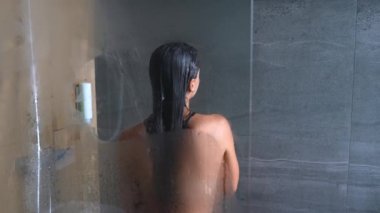 Duşta yıkanan ve dans eden genç bir kadın