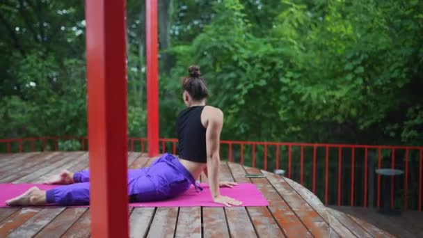 ベランダの庭でヨガをしている若い女性 — ストック動画