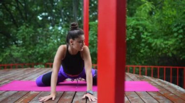 Verandada yoga yapan genç bir kadın.