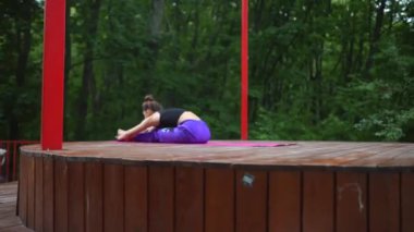 Verandada yoga yapan genç bir kadın.