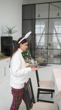 Oturma odasında yeni yıl sofrası kuran kadın..