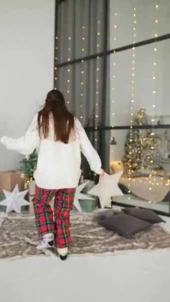 若い女性がクリスマスツリーに駆け上がり 近くの贈り物で喜びます — ストック動画