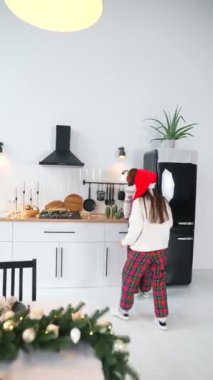Mutfakta iki kız yemek pişiriyor. Kadınlar yeni yıla hazırlanıyor. Mutfakta birbirine yardım eden iki kız.