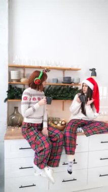 Kadınlar mutfaktaki bardaklarla bir masada oturuyorlar.