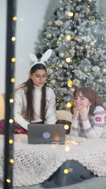2人の若い女性が大晦日のラップトップでインターネットをサーフィン — ストック動画