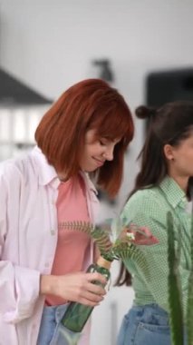 Mutfakta iki kadın çiçeklerle ilgileniyor.