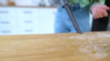 Mutfak masasını fırçasız süpüren kadın.