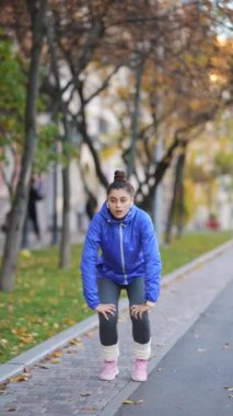 Koşu yapmadan önce etkin bir spor kadınının bacaklarını ısıtması.