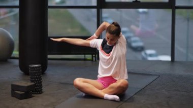 Genç, çekici bir kadın yoga yapıyor, egzersiz yapıyor spor kıyafetleri giyiyor.