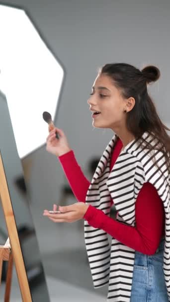 Feliz Joven Mujer Aplica Maquillaje Cara Delante Del Espejo — Vídeo de stock