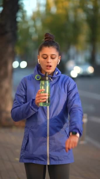 Biegaczka Stojąca Zewnątrz Pijąca Wodę Butelki Fitness Kobieta Robi Przerwę — Wideo stockowe