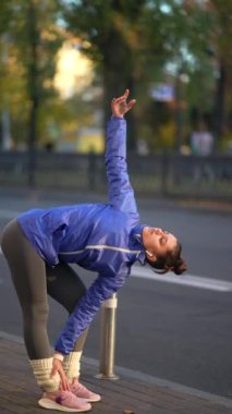 Fitness ikincisi koşmadan önce ısınıyor ve esniyor. Spor Giyim ve Isınma dallarında Atletizm Eğitimi