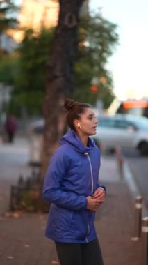 Spor giyimli bayan sporcu şehir sokaklarında ısınma egzersizleri yapıyor.