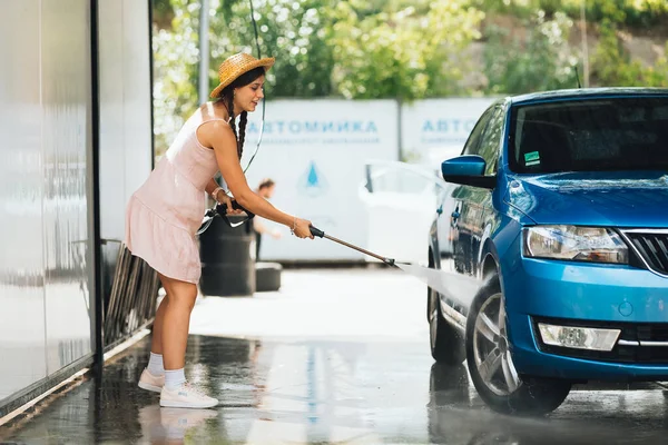 stock image Brunette from a high-pressure hose washes the car at a car wash