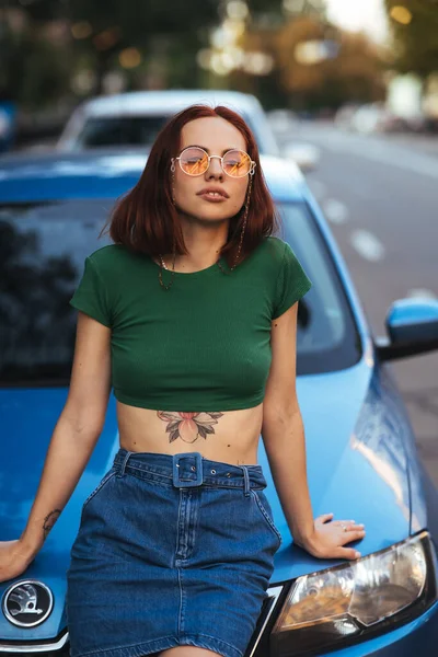 Beautiful Girl Sunglasses Sits Hood Blue Car Road — Stock Photo, Image